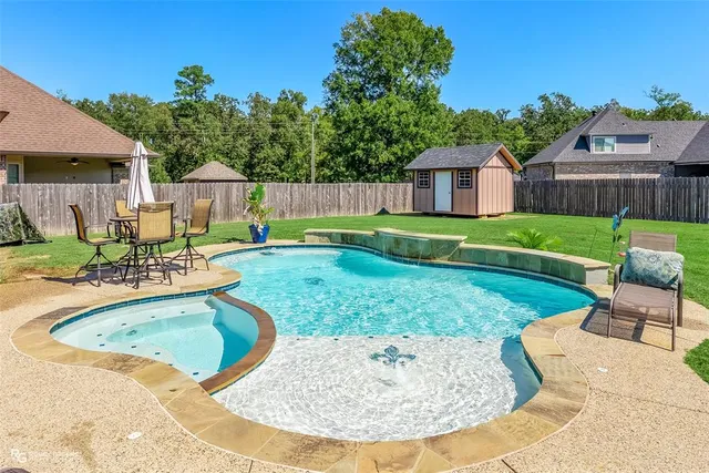 a view of a house with backyard and sitting area