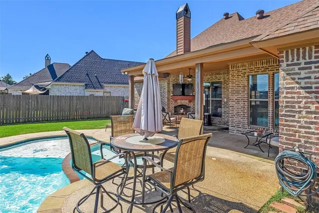 a view of a patio with table and chairs with wooden floor and fence