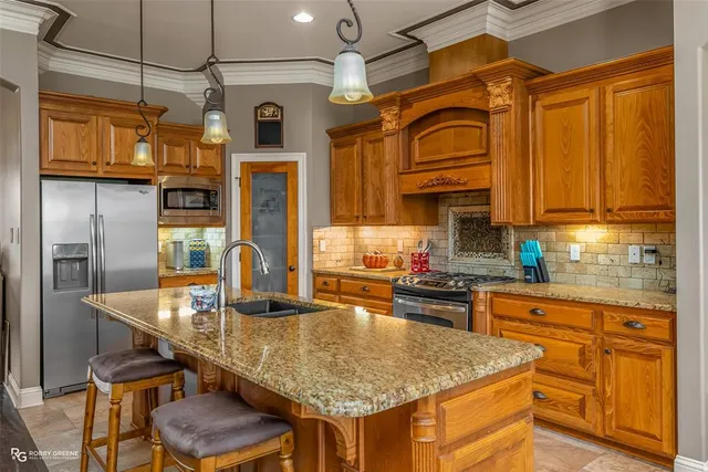 a kitchen with stainless steel appliances granite countertop a stove refrigerator and cabinets