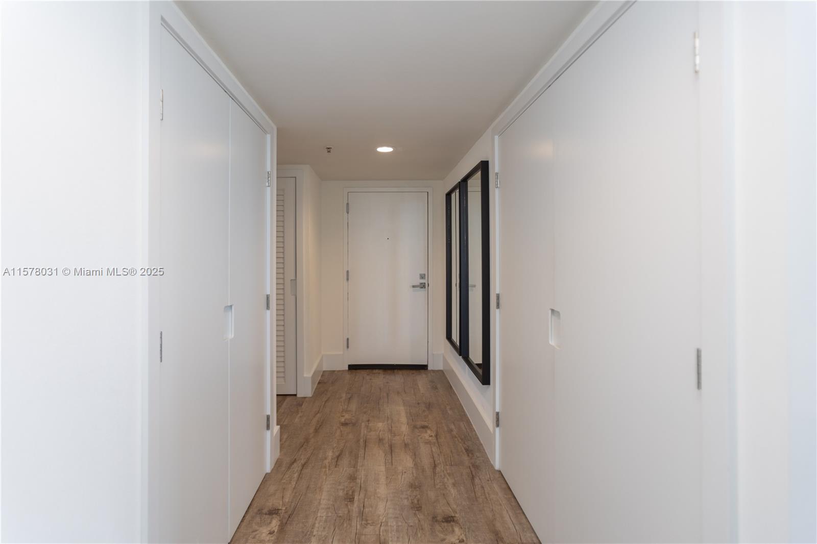 a view of a hallway with wooden floor