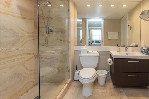 a bathroom with a toilet a sink and glass door