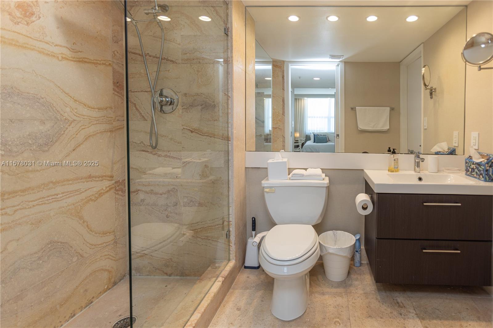 90 Alton Road, Unit 1411 Miami Beach, FL 33139 - Photo 15 of 36 a bathroom with a toilet a sink and glass door