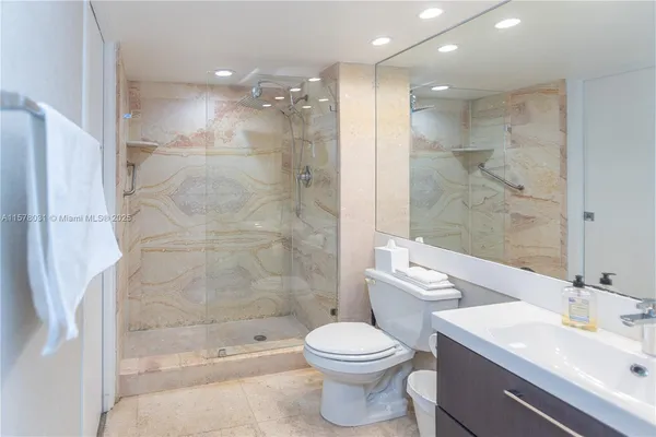 a bathroom with a bathtub shower sink mirror and toilet