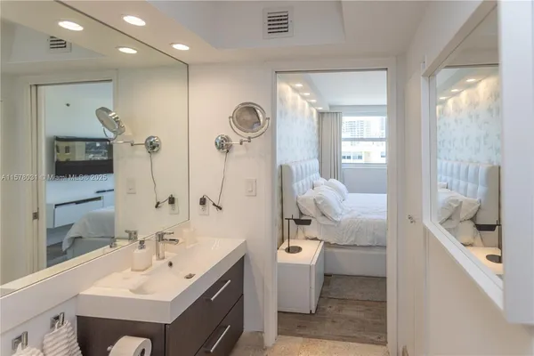 a en suite bathroom with a double vanity sink a mirror and a shower