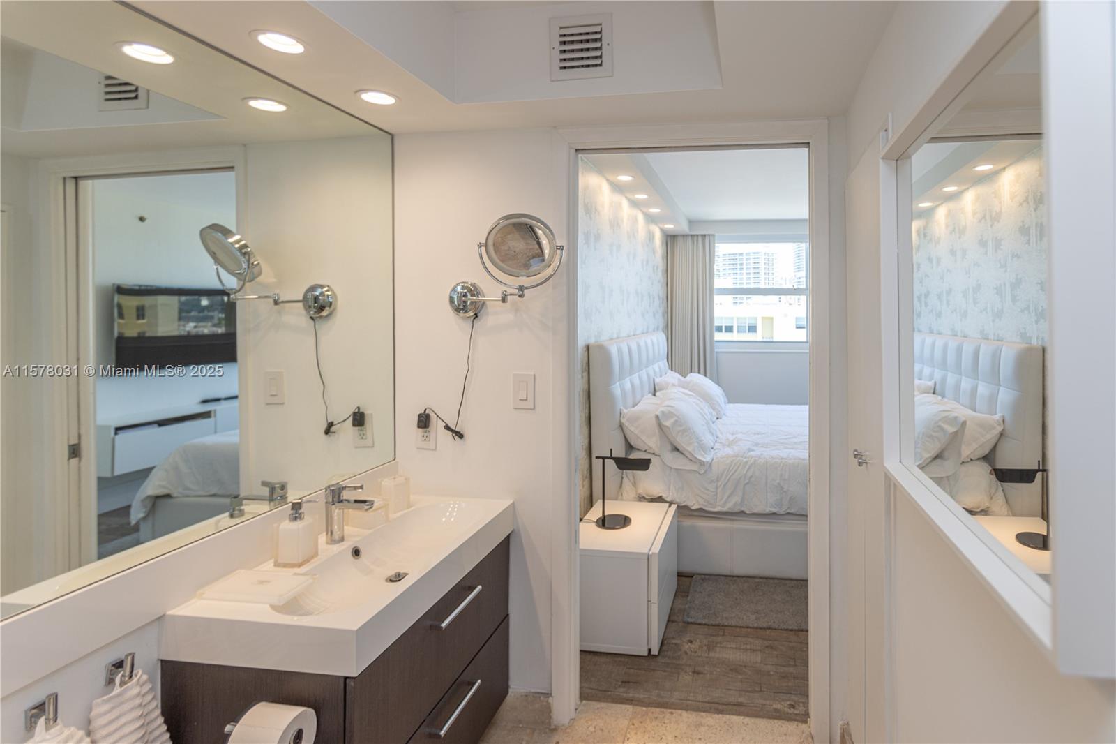 90 Alton Road, Unit 1411 Miami Beach, FL 33139 - Photo 17 of 36 a en suite bathroom with a double vanity sink a mirror and a shower