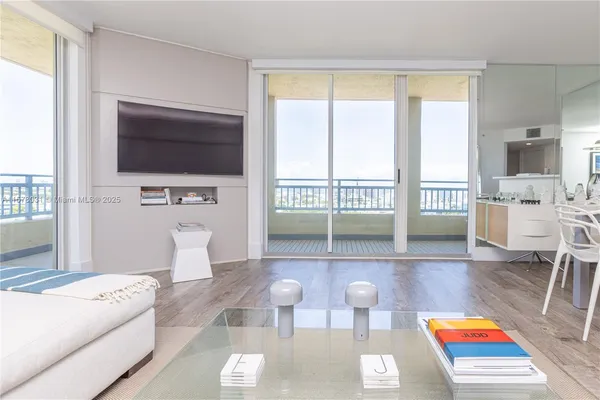 a living room with furniture a flat screen tv and a large window