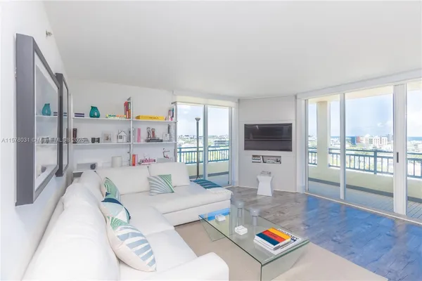a living room with furniture a flat screen tv and a large window