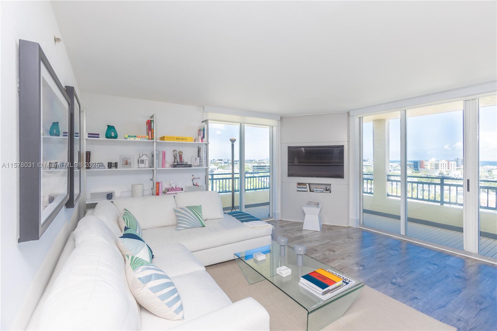 90 Alton Road, Unit 1411 Miami Beach, FL 33139 - Photo 6 of 36 a living room with furniture a flat screen tv and a large window
