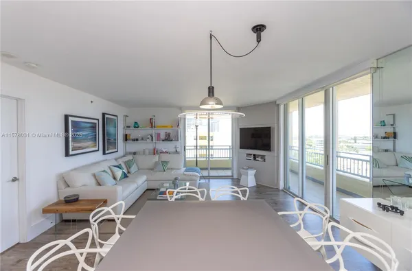 a living room with furniture a flat screen tv and a large window
