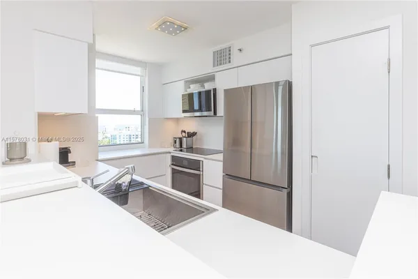 a kitchen with stainless steel appliances a refrigerator and a stove top oven