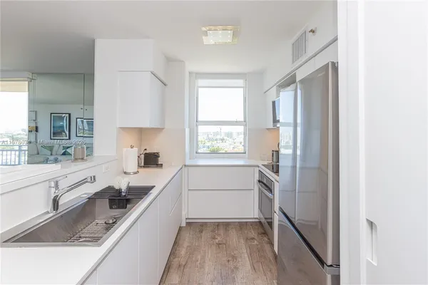a kitchen with a refrigerator sink and cabinets