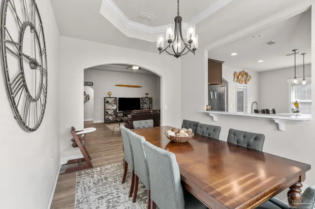 a view of a dining room with furniture a chandelier and wooden floor