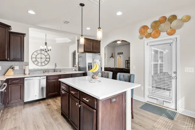 a kitchen with a sink a counter space appliances and cabinets