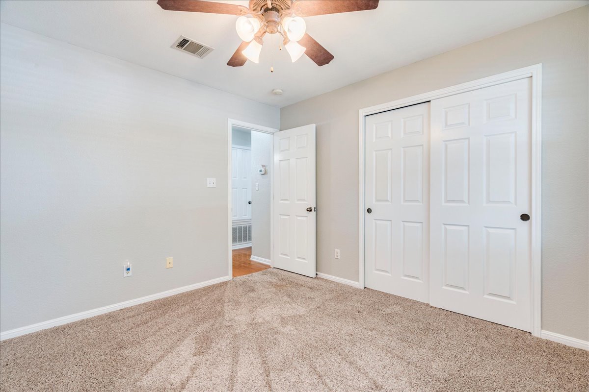 1151 Stone Rim Loop Buda, TX 78610 - Photo 21 of 36 Second Bedroom featuring light-colored walls, carpeted flooring, and a ceiling fan with integrated lighting