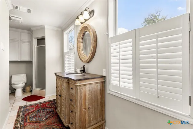 a bathroom with a sink a toilet and a window