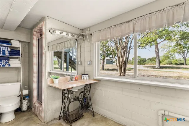 a bathroom with a sink toilet and a mirror