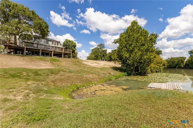 a view of a big yard with swimming pool and green space