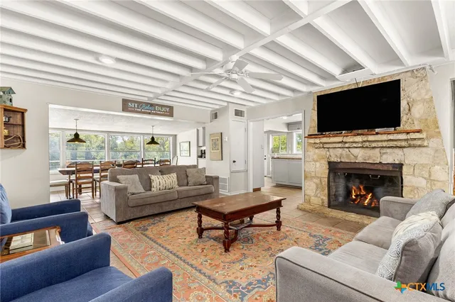 a living room with furniture a fireplace and a flat screen tv