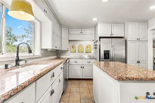 a kitchen with refrigerator cabinets and a sink