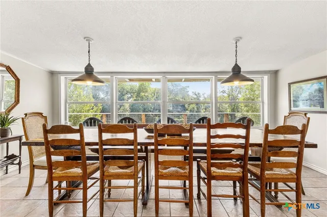 a dining room with furniture large windows and a chandelier
