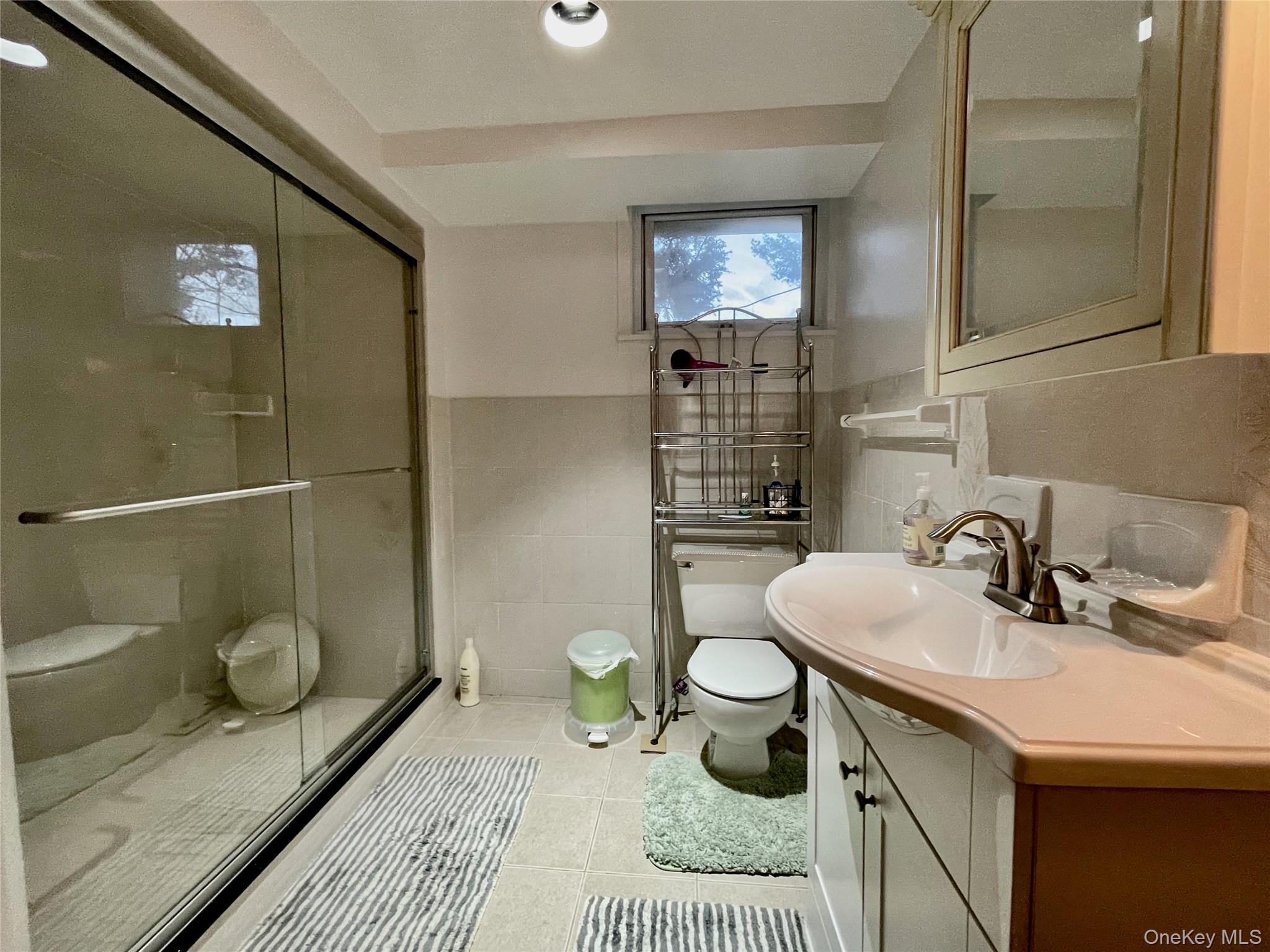 169 Old Mamaroneck Road, Unit B1 White Plains, NY 10605 - Photo 5 of 11 a bathroom with a sink a toilet and a mirror