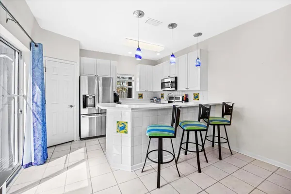 a kitchen with kitchen island a white cabinets and chairs