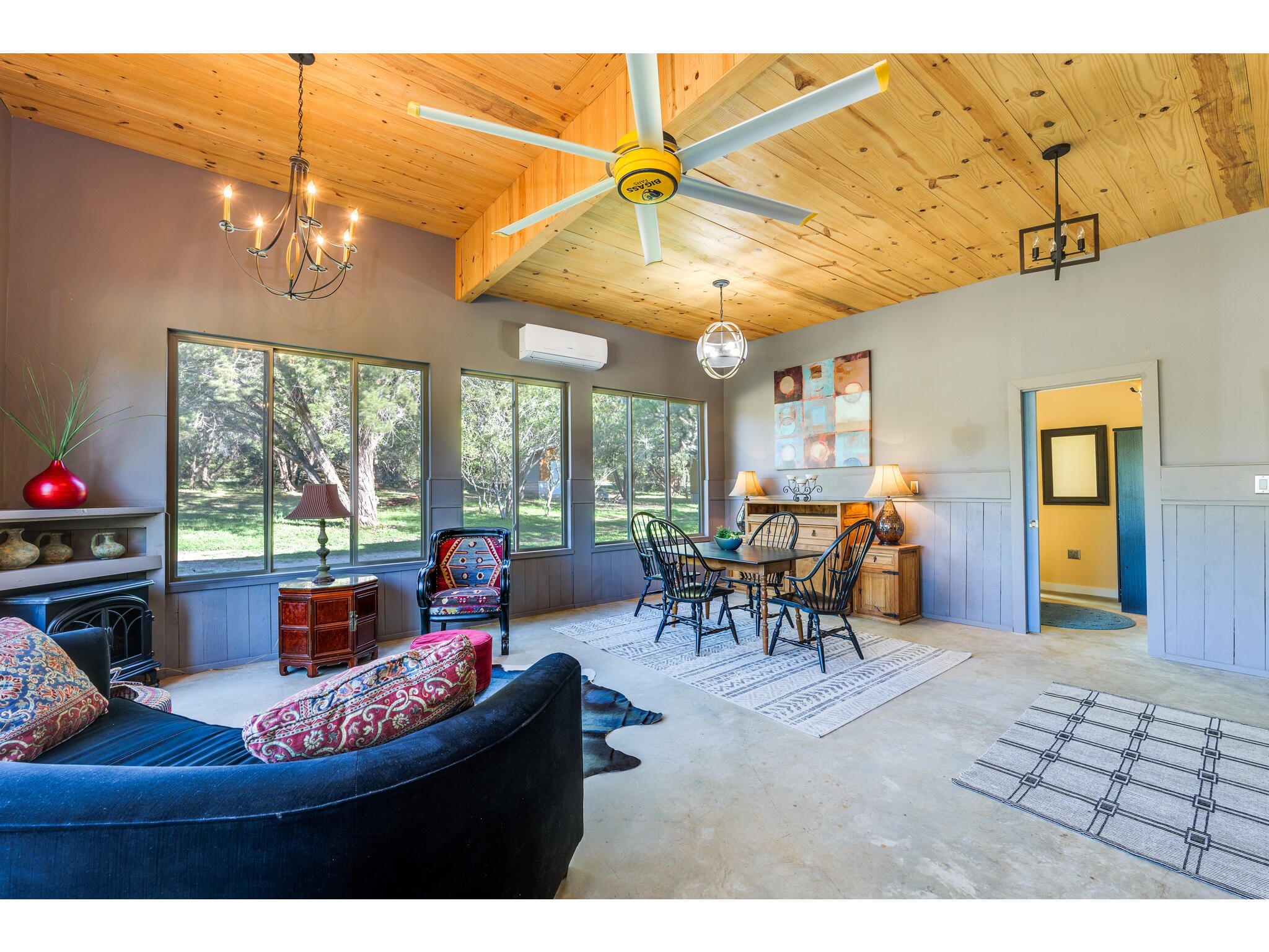 250 Caliche Road Wimberley, TX 78676 - Photo 1 of 40 a living room with furniture a chandelier and a floor to ceiling window