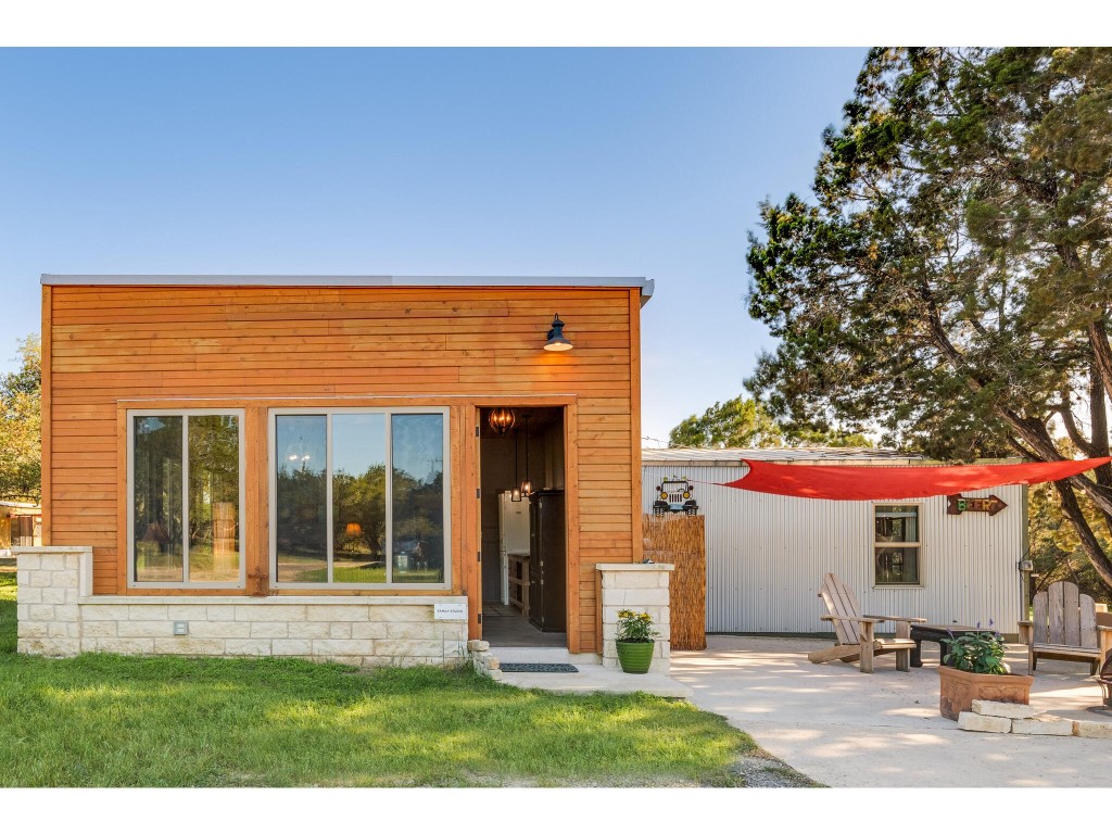 250 Caliche Road Wimberley, TX 78676 - Photo 14 of 40 a front view of a house with a yard and potted plants