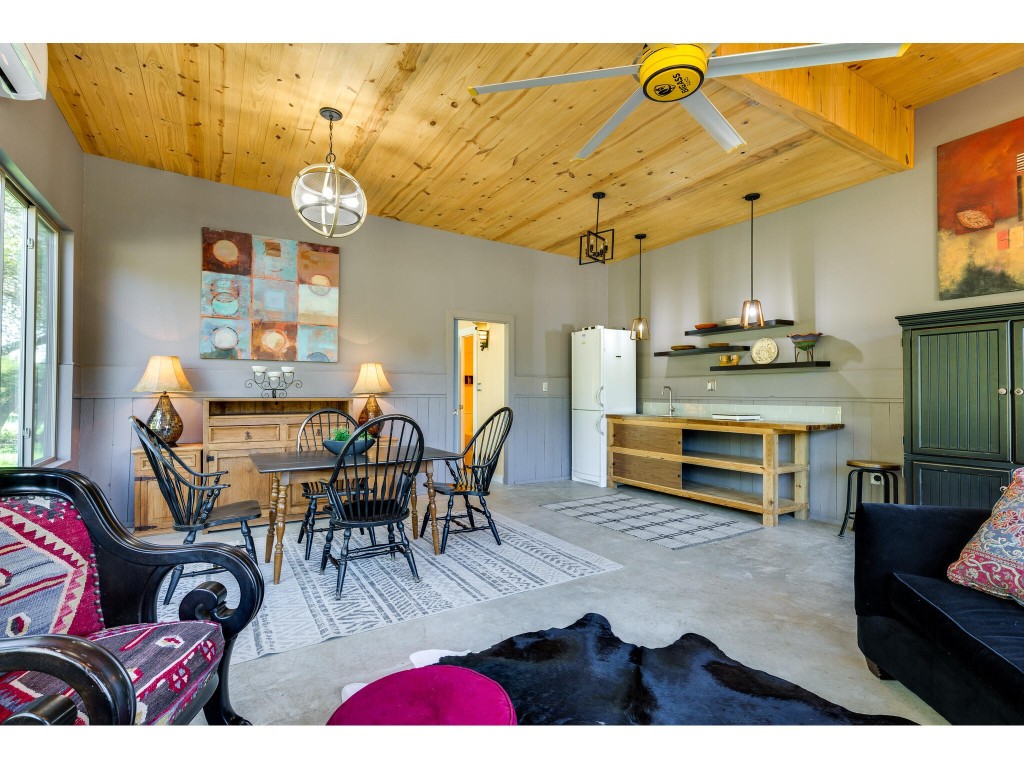 250 Caliche Road Wimberley, TX 78676 - Photo 16 of 40 a living room with lots of furniture and paintings on the wall