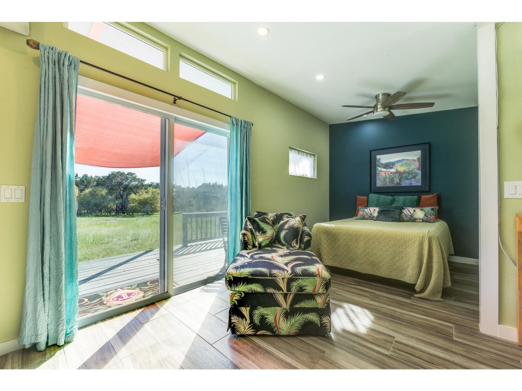 250 Caliche Road Wimberley, TX 78676 - Photo 24 of 40 a bedroom with a bed and a large window