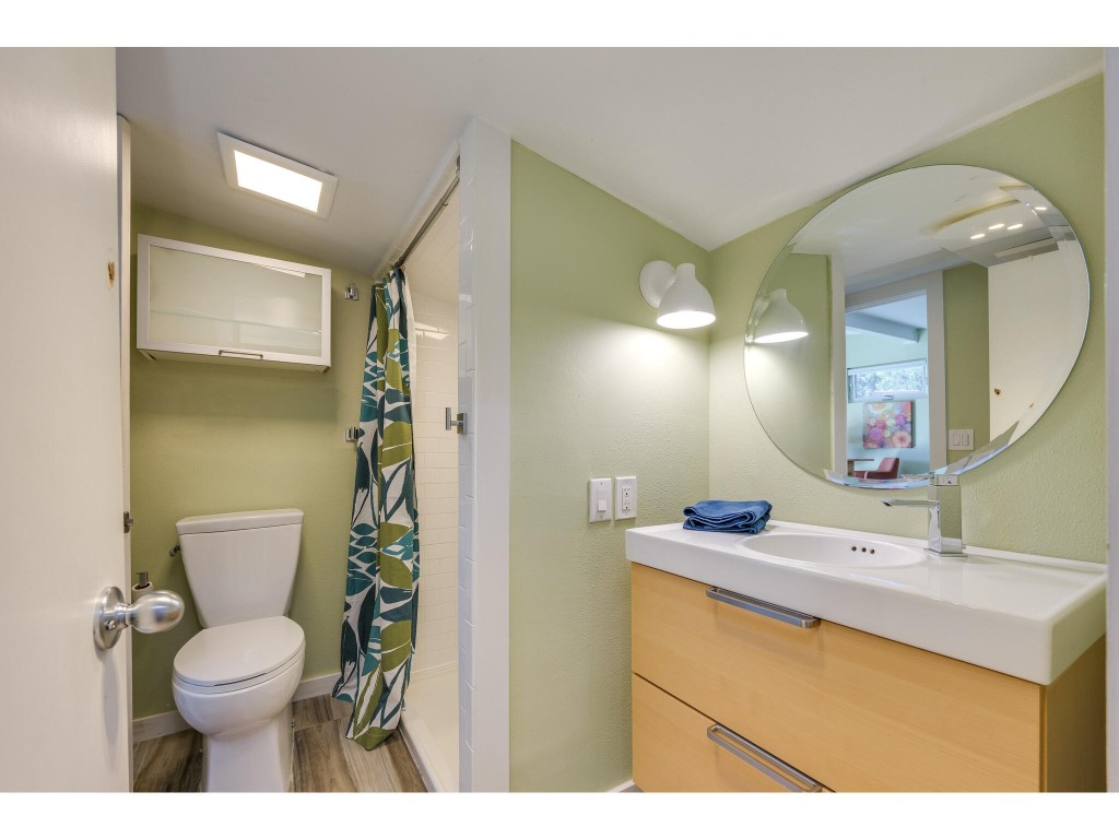 250 Caliche Road Wimberley, TX 78676 - Photo 27 of 40 a bathroom with a toilet sink and mirror