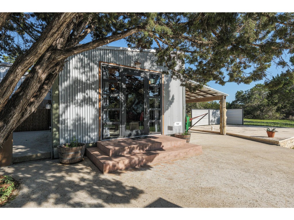 250 Caliche Road Wimberley, TX 78676 - Photo 28 of 40 a backyard of a house with large trees and outdoor seating