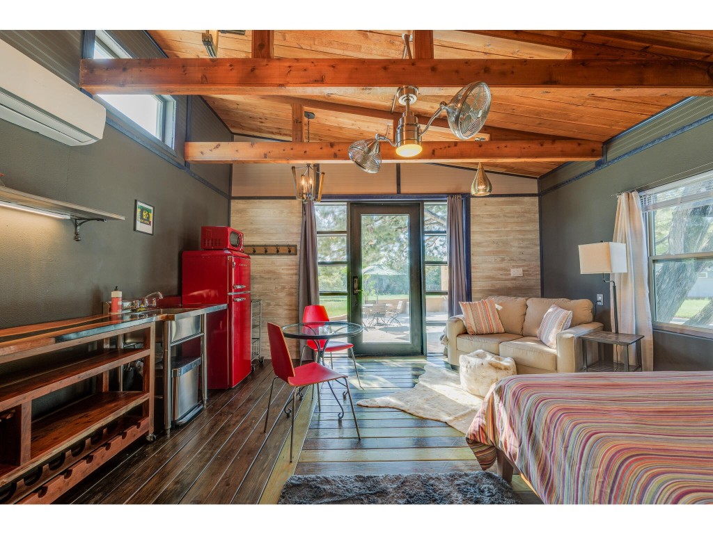 250 Caliche Road Wimberley, TX 78676 - Photo 29 of 40 a bedroom with furniture and a large window