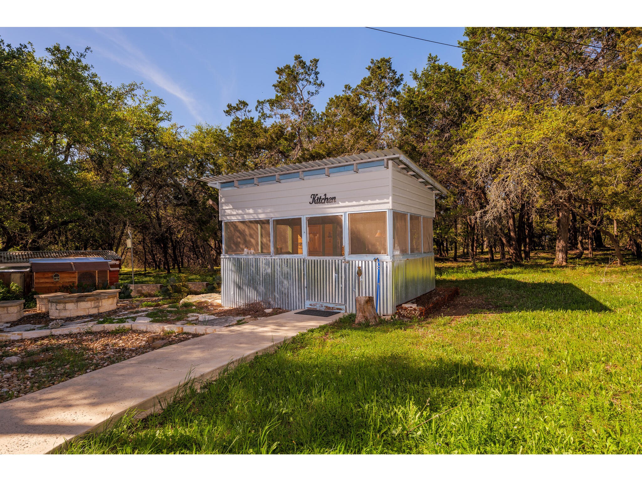 250 Caliche Road Wimberley, TX 78676 - Photo 35 of 40 a view of a house with backyard and sitting area