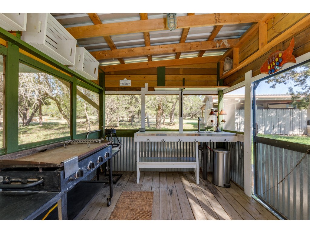 250 Caliche Road Wimberley, TX 78676 - Photo 36 of 40 a view of a patio with a table chairs and wooden floor