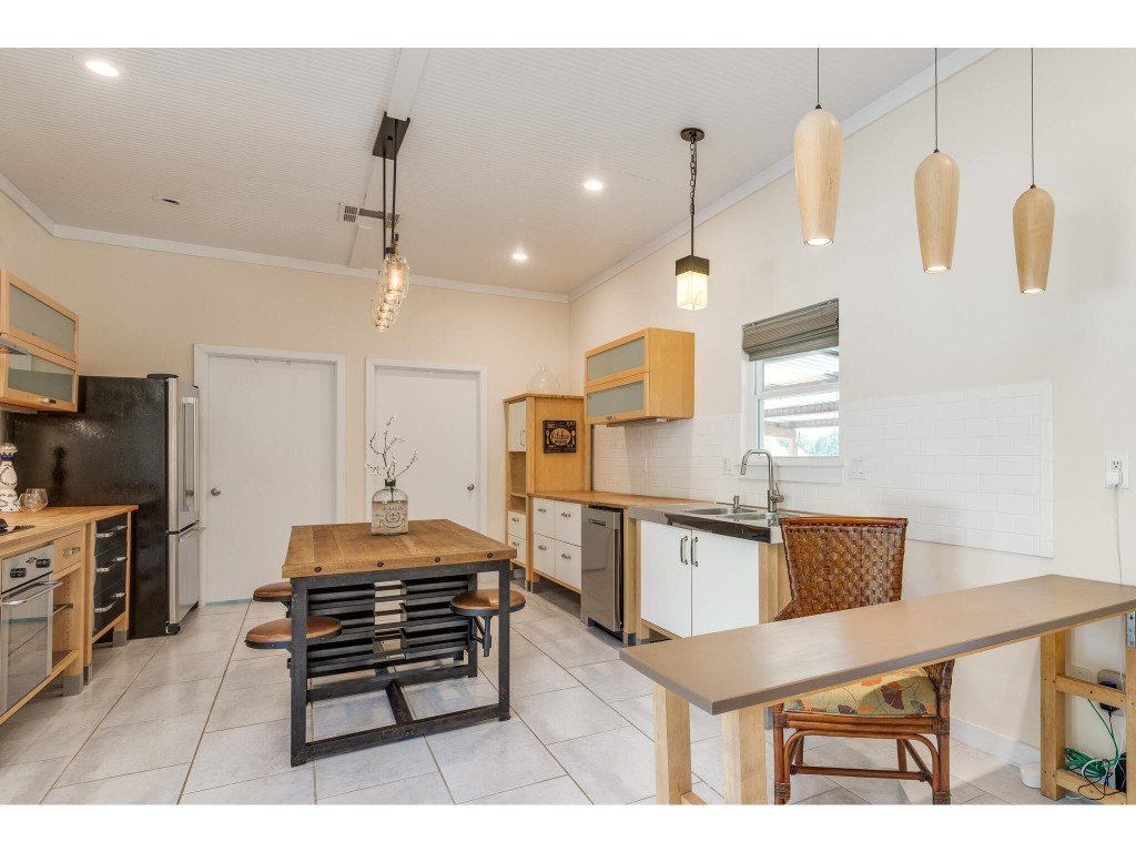 250 Caliche Road Wimberley, TX 78676 - Photo 6 of 40 a kitchen with stainless steel appliances kitchen island granite countertop a refrigerator and a stove top oven