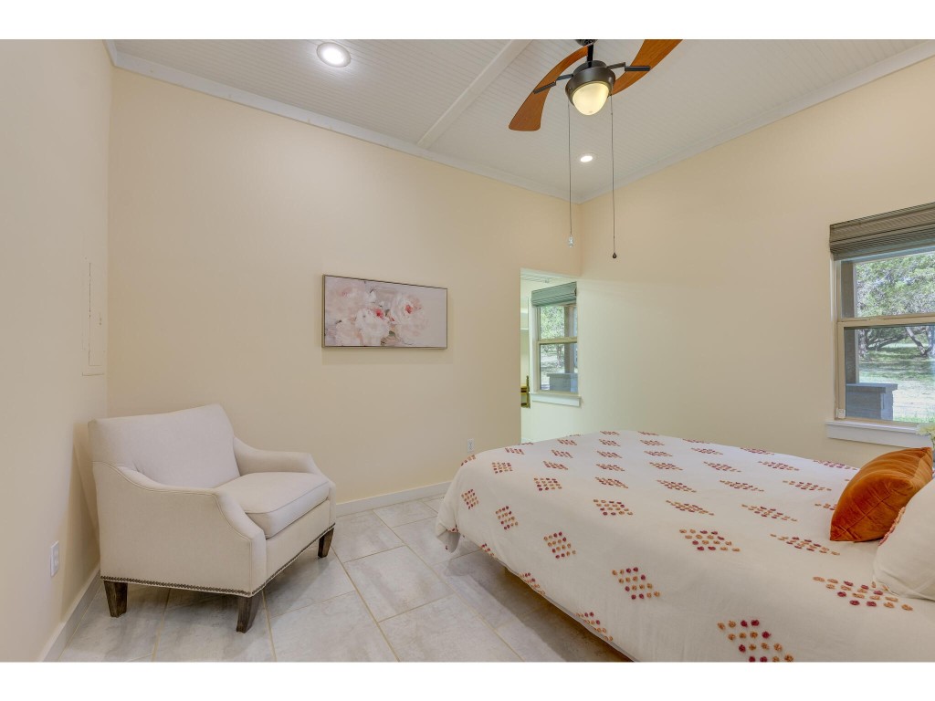 250 Caliche Road Wimberley, TX 78676 - Photo 9 of 40 a bedroom with a bed couch and a window