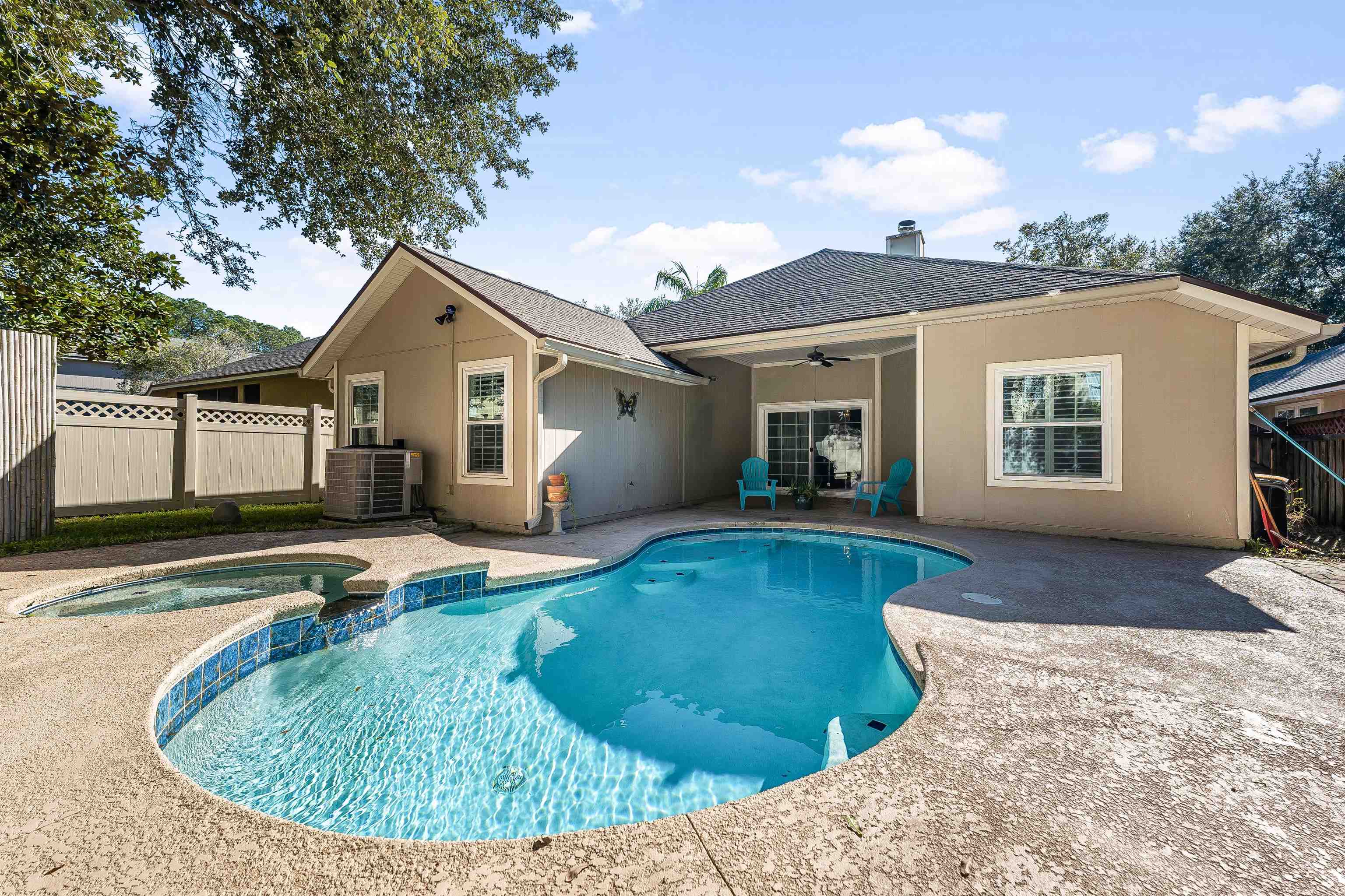 a view of a house with pool fire pit next to a yard