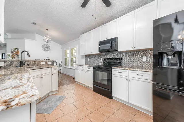 a kitchen with granite countertop a sink stainless steel appliances and cabinets
