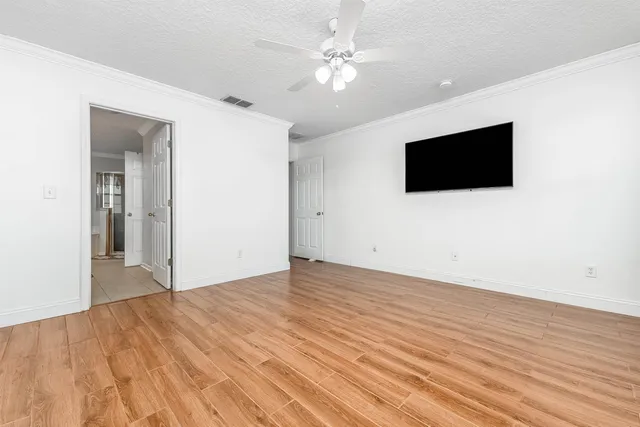 en empty room with window and a flat screen tv