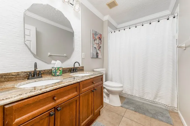 a bathroom with a granite countertop sink a toilet and a mirror