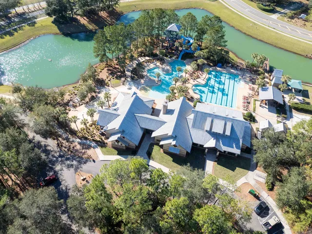 an aerial view of a house with a garden and lake view