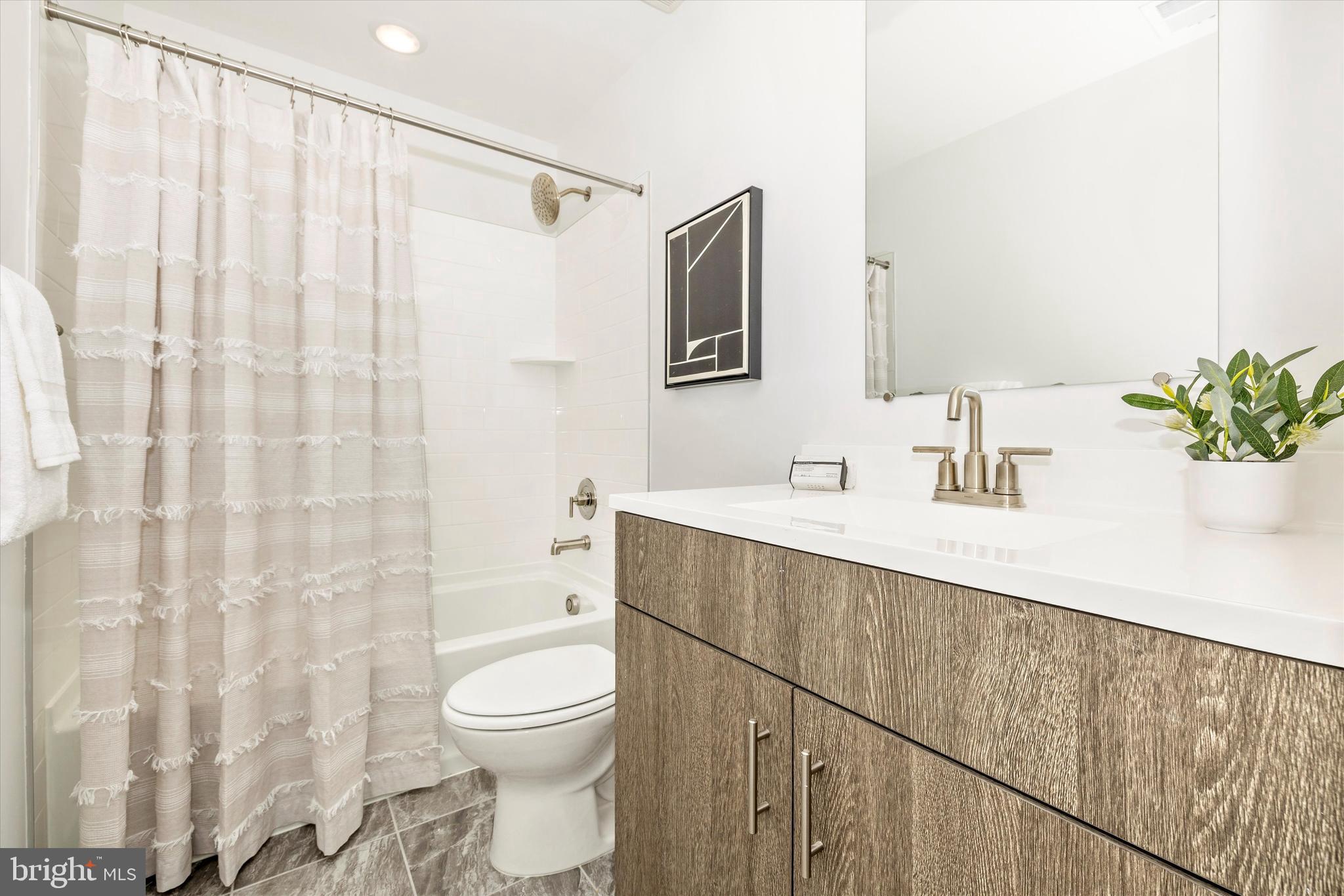 709 Iron Frg Road, Unit B Frederick, MD 21702 - Photo 31 of 32 a bathroom with a sink a toilet and shower curtain