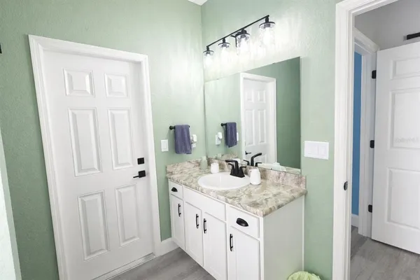 a bathroom with a granite countertop sink and a mirror