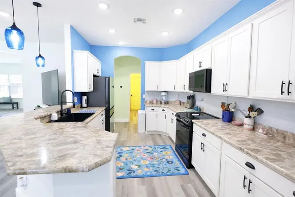 a kitchen with stainless steel appliances kitchen island granite countertop a sink stove and refrigerator