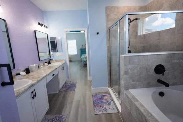 a bathroom with a tub sink and mirror