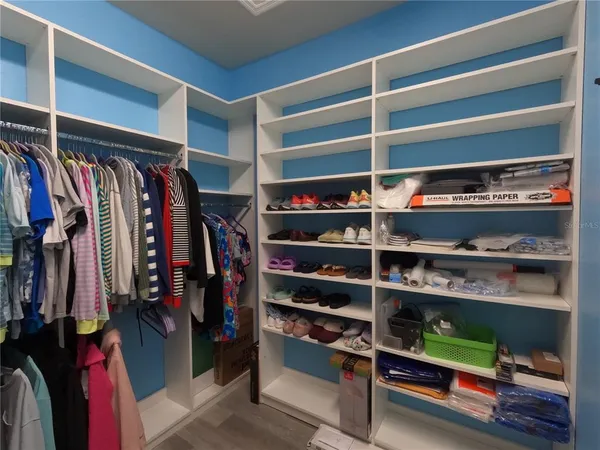 a view of walk in closet with clothes and shoes