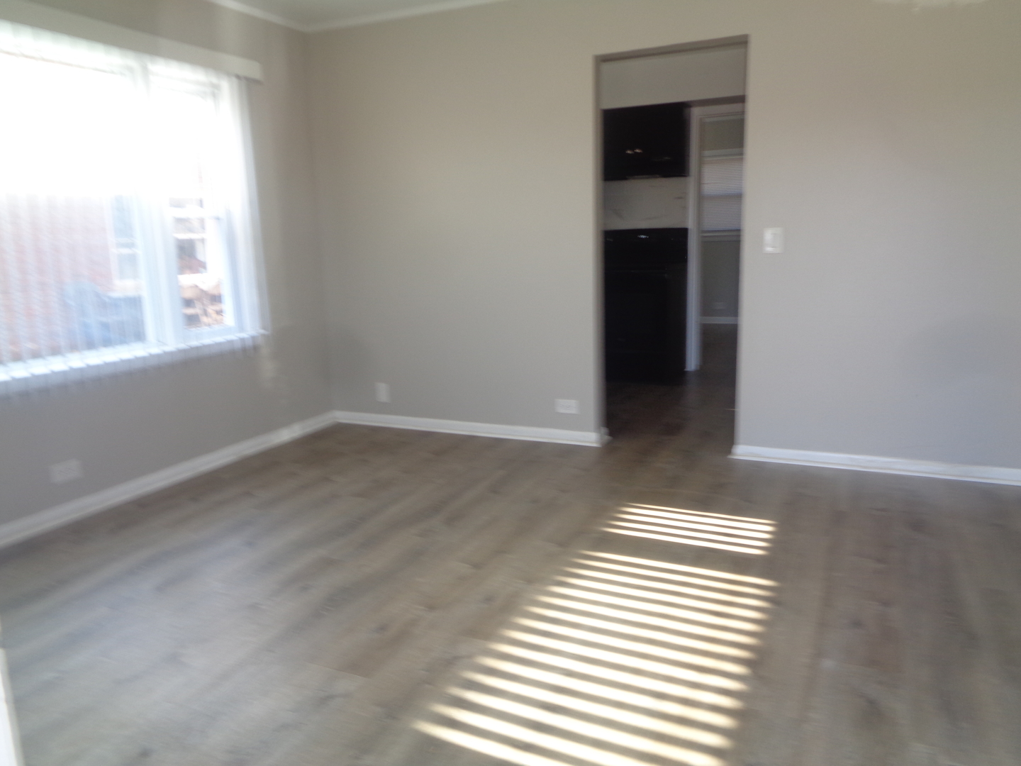 1340 North Main Street, Unit E1 Wheaton, IL 60187 - Photo 2 of 8 an empty room with wooden floor and windows
