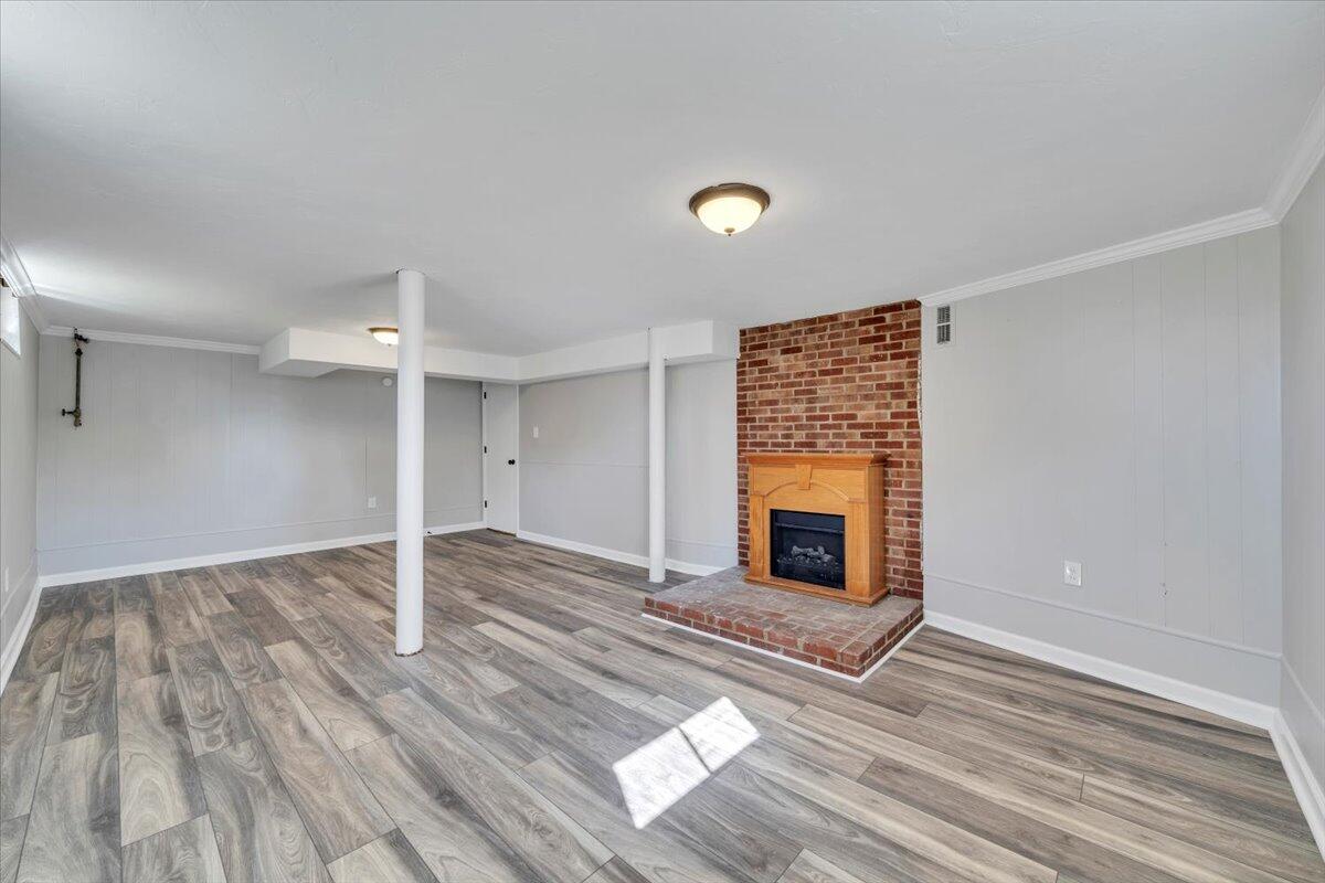 210 Post Road Roanoke, VA 24019 - Photo 24 of 56 an empty room with wooden floor fireplace and windows