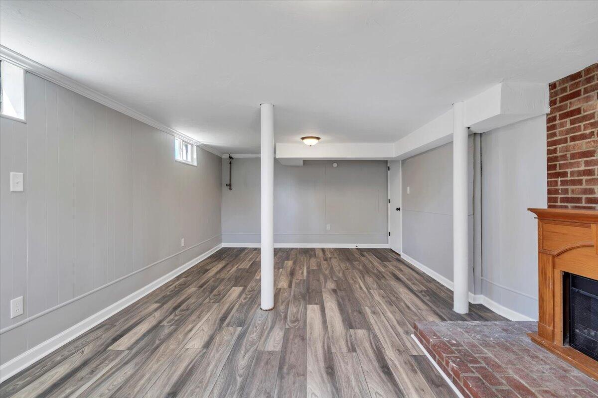 210 Post Road Roanoke, VA 24019 - Photo 27 of 56 a view of an empty room with wooden floor a fireplace and windows